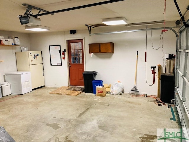 garage featuring white fridge, refrigerator, and a garage door opener