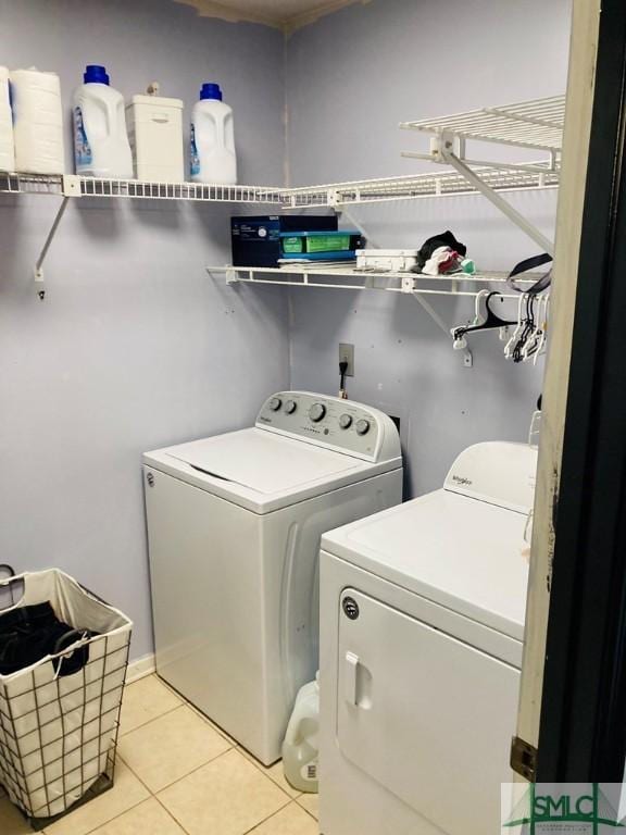 laundry area featuring washing machine and dryer and light tile patterned flooring