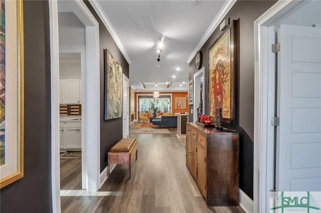 corridor with hardwood / wood-style floors and ornamental molding