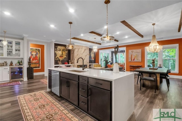 kitchen with sink, beverage cooler, stainless steel dishwasher, dark hardwood / wood-style floors, and a center island with sink