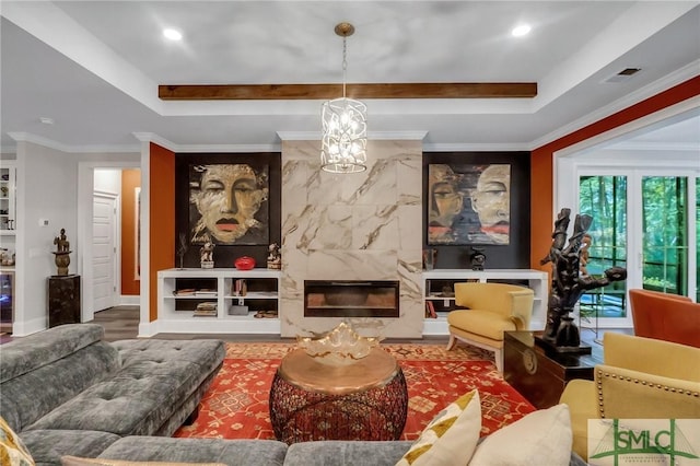 living room featuring hardwood / wood-style floors, crown molding, a fireplace, and a tray ceiling