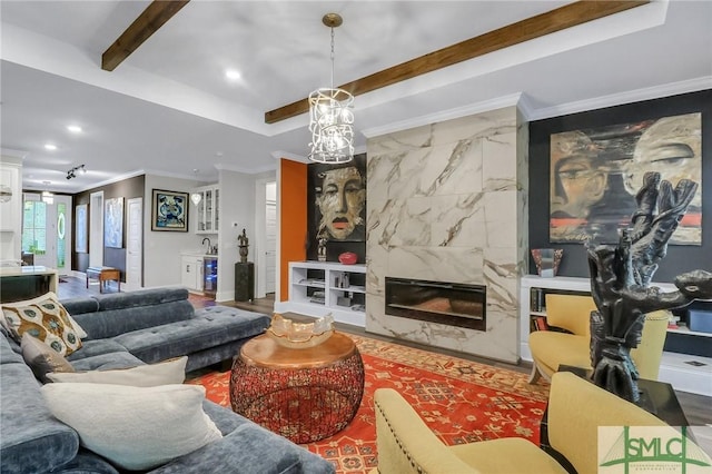 living room with a raised ceiling, crown molding, and a fireplace