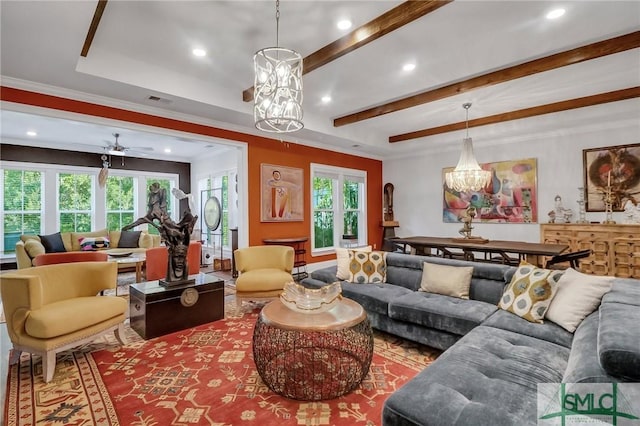 living room with a tray ceiling, ceiling fan, and crown molding