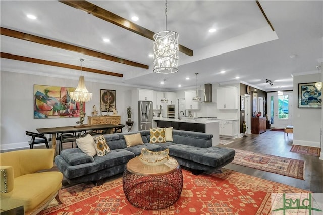 living room featuring wood-type flooring, a notable chandelier, ornamental molding, and sink