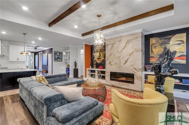 living room with a raised ceiling, a premium fireplace, dark hardwood / wood-style floors, and ornamental molding