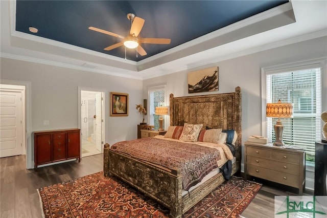 bedroom featuring connected bathroom, a tray ceiling, ceiling fan, and ornamental molding