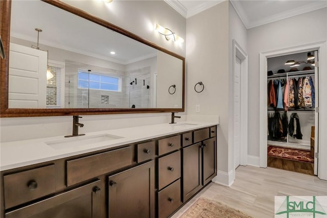 bathroom with vanity, an enclosed shower, and crown molding