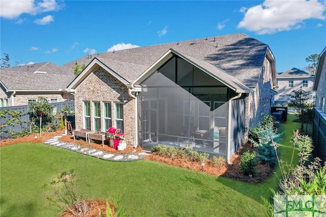 back of property with a lawn and a sunroom