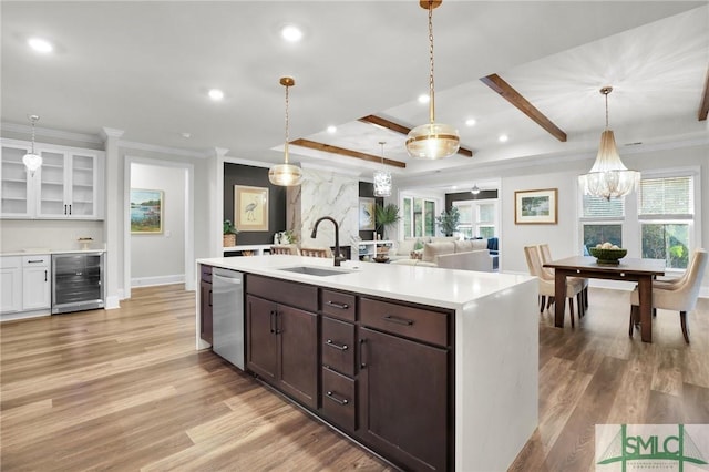 kitchen with wine cooler, light wood finished floors, light countertops, a sink, and dishwasher