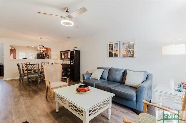 living room featuring hardwood / wood-style floors and ceiling fan with notable chandelier