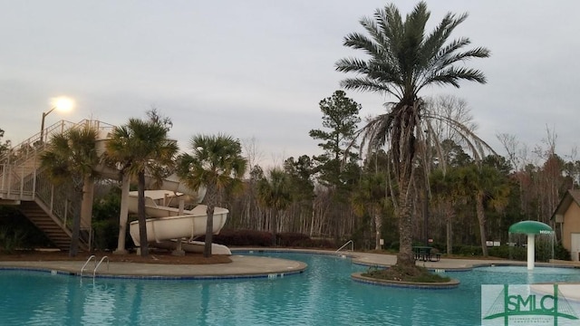 community pool with stairs and a patio area