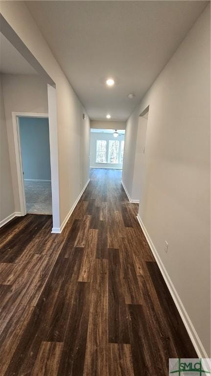 hallway with baseboards, dark wood-style flooring, and recessed lighting