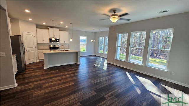 kitchen featuring stainless steel appliances, tasteful backsplash, visible vents, a sink, and baseboards