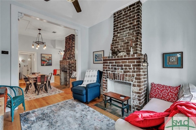 living room featuring hardwood / wood-style floors, a brick fireplace, and ceiling fan