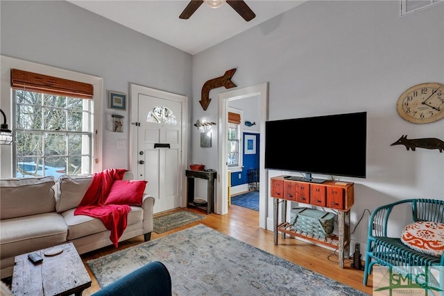 living room with light hardwood / wood-style floors and ceiling fan