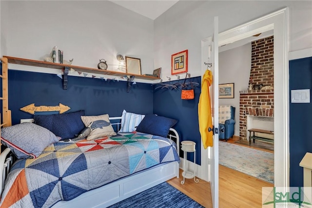 bedroom featuring hardwood / wood-style flooring and a fireplace