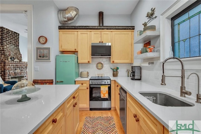 kitchen featuring decorative backsplash, light brown cabinetry, stainless steel appliances, and sink