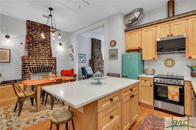 kitchen featuring a kitchen bar, light brown cabinetry, stainless steel range with electric cooktop, and pendant lighting