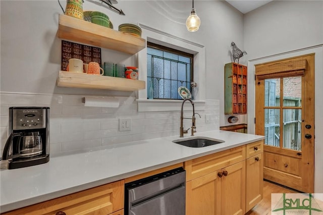 kitchen with sink, light brown cabinets, hanging light fixtures, stainless steel dishwasher, and backsplash