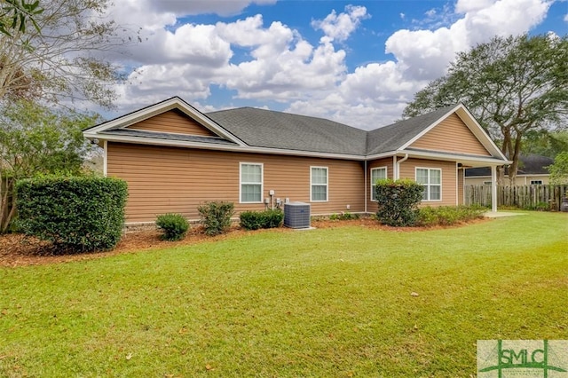 rear view of property featuring a yard and central AC