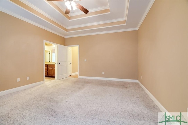 unfurnished bedroom featuring carpet flooring, ceiling fan, ornamental molding, and a tray ceiling