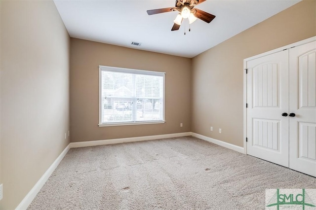 unfurnished bedroom featuring light carpet, a closet, and ceiling fan