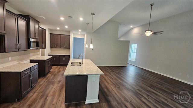 174 Brookline Dr, Savannah, GA 31407 - kitchen featuring stainless steel microwave, dark brown cabinets, a kitchen island with sink, a ceiling fan, and dark wood-type flooring