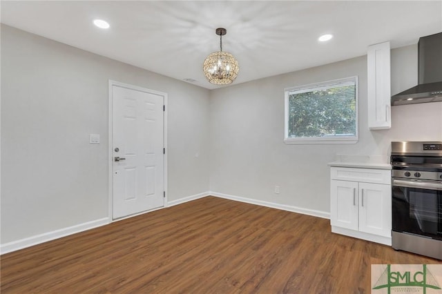 interior space with wall chimney exhaust hood, decorative light fixtures, an inviting chandelier, stainless steel range oven, and white cabinets