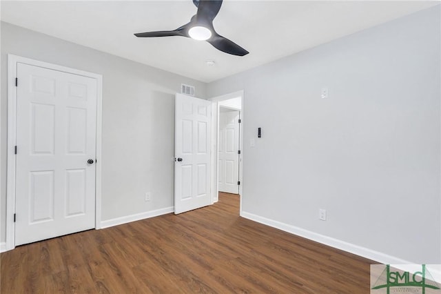 unfurnished bedroom featuring ceiling fan and dark wood-type flooring