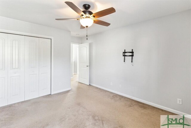 unfurnished bedroom with light carpet, a closet, and ceiling fan