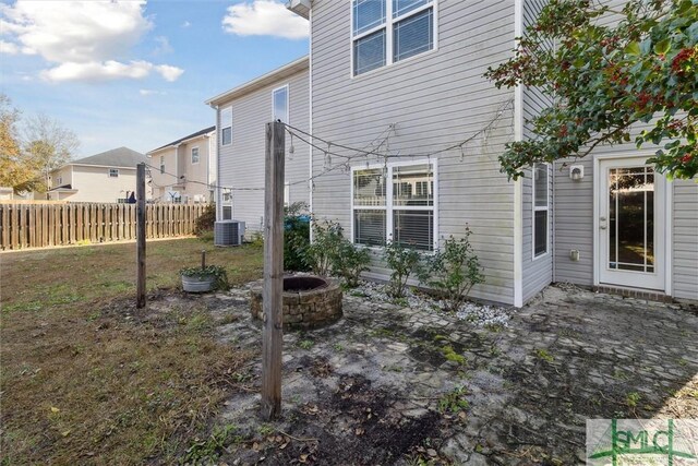 rear view of property featuring central AC and an outdoor fire pit