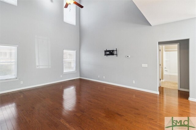 unfurnished living room featuring a towering ceiling and a healthy amount of sunlight