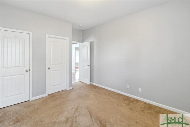 unfurnished bedroom featuring light carpet