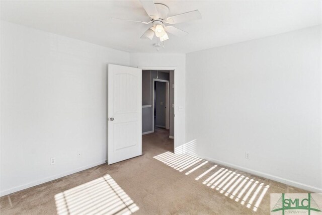 spare room with ceiling fan and light carpet