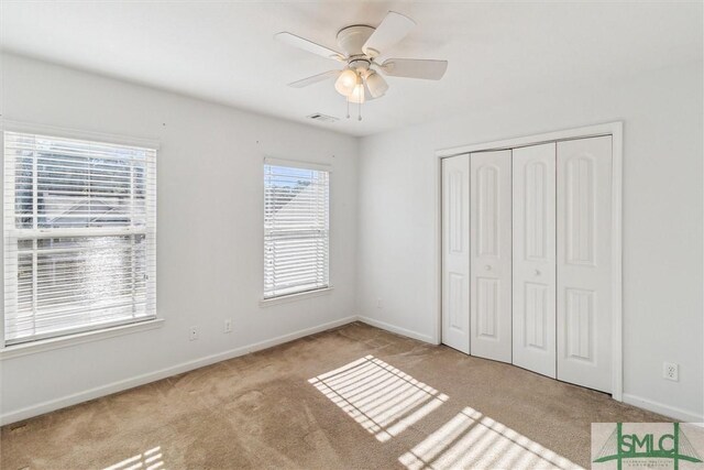 unfurnished bedroom with ceiling fan, light colored carpet, and a closet