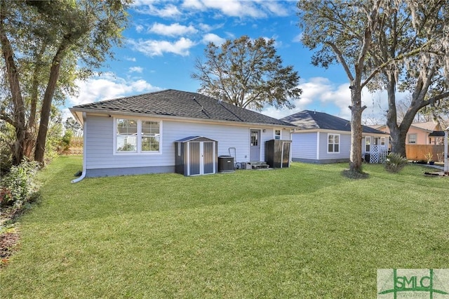 rear view of property featuring a storage unit, a yard, and central AC