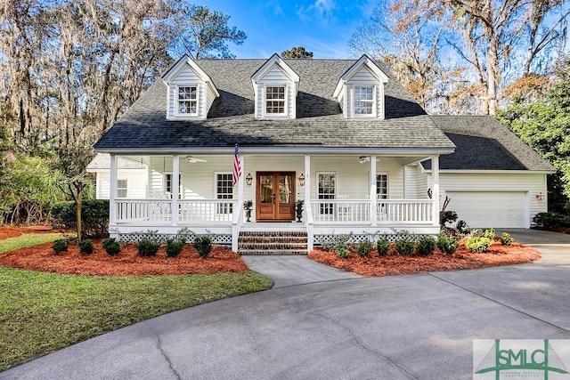 cape cod-style house with a garage, covered porch, and a front lawn