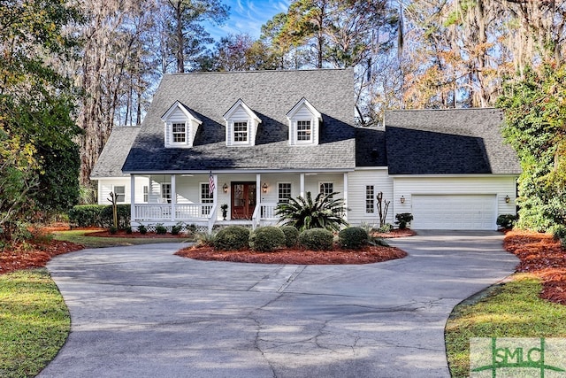 cape cod house with a garage and covered porch