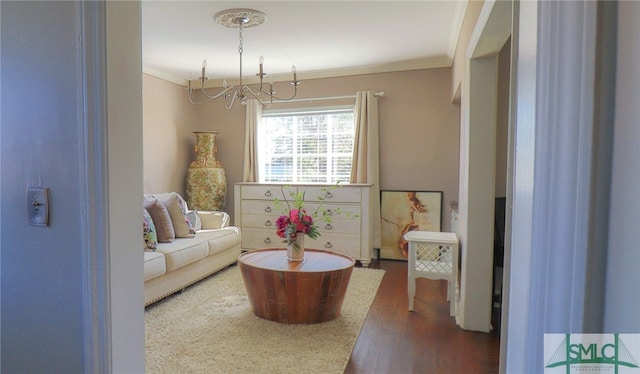 living area with dark wood-type flooring, crown molding, and a notable chandelier