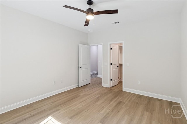 130 N Skinner Ave, Pooler, GA 31322 - unfurnished bedroom with light wood-style flooring, baseboards, a walk in closet, and ceiling fan