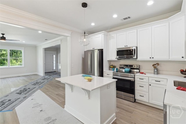130 N Skinner Ave, Pooler, GA 31322 - kitchen with appliances with stainless steel finishes, ornamental molding, a kitchen island, light wood-style flooring, and light countertops