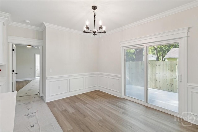130 N Skinner Ave, Pooler, GA 31322 - unfurnished dining area featuring a chandelier, light wood-style flooring, crown molding, a wainscoted wall, and a decorative wall