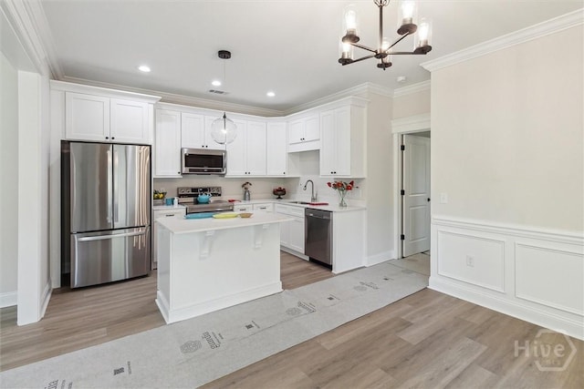 130 N Skinner Ave, Pooler, GA 31322 - kitchen featuring appliances with stainless steel finishes, light wood-type flooring, white cabinetry, a sink, and ornamental molding