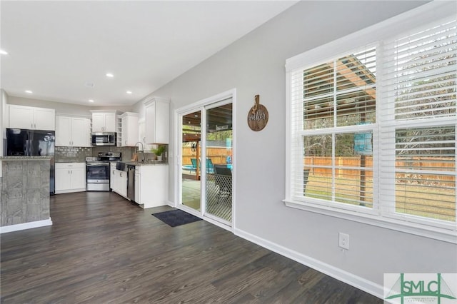 kitchen with plenty of natural light, white cabinetry, and appliances with stainless steel finishes