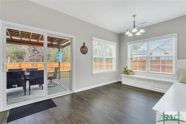 dining area featuring dark hardwood / wood-style floors and an inviting chandelier