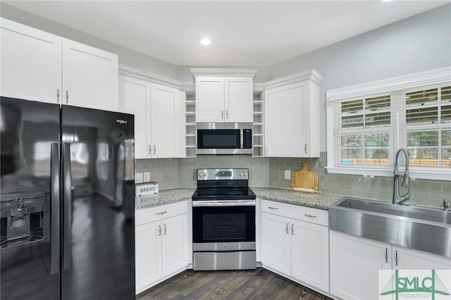 kitchen featuring decorative backsplash, white cabinetry, sink, and appliances with stainless steel finishes