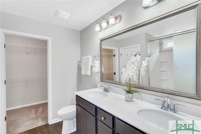 bathroom featuring vanity, toilet, wood-type flooring, and walk in shower