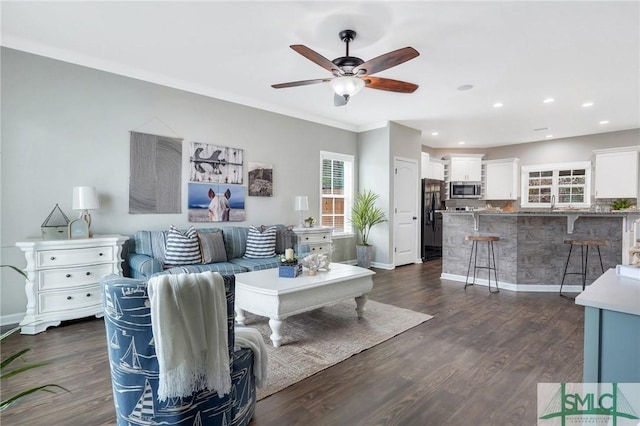 living room with dark hardwood / wood-style floors, ceiling fan, and crown molding