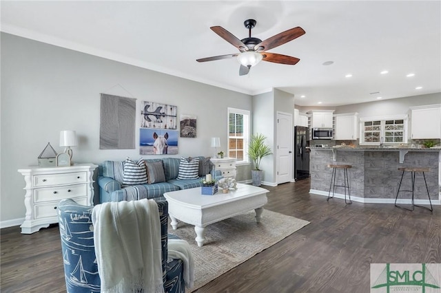 living room with ceiling fan, crown molding, and dark wood-type flooring