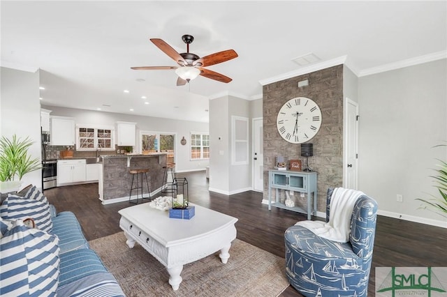 living room with ceiling fan, dark hardwood / wood-style flooring, ornamental molding, and sink